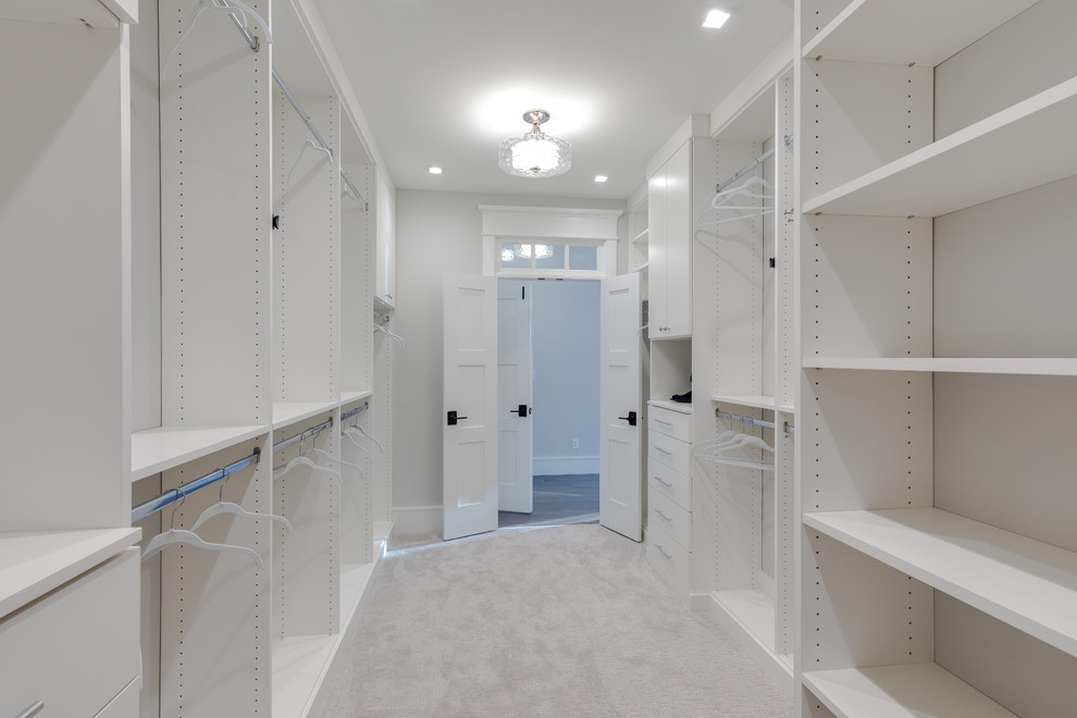 На фото: большая гардеробная комната унисекс в стиле модернизм с плоскими фасадами, белыми фасадами, ковровым покрытием и серым полом с
