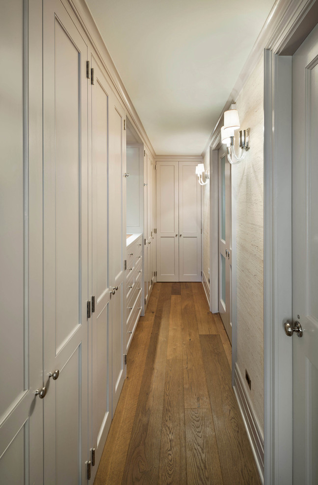 Example of a transitional gender-neutral medium tone wood floor dressing room design in New York with beige cabinets