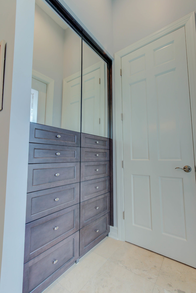 Photo of a small classic dressing room for men in Other with flat-panel cabinets and dark wood cabinets.