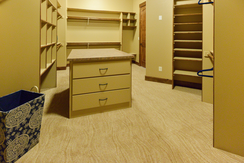 Exemple d'un très grand dressing craftsman neutre avec un placard sans porte, moquette et un sol beige.