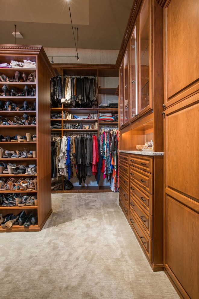 Foto de armario vestidor unisex tradicional de tamaño medio con armarios con paneles con relieve, puertas de armario de madera oscura, moqueta y suelo beige