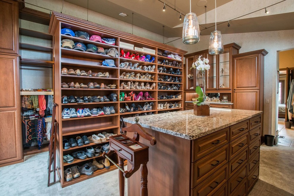 Example of a mid-sized classic gender-neutral carpeted and beige floor walk-in closet design in Denver with raised-panel cabinets and medium tone wood cabinets