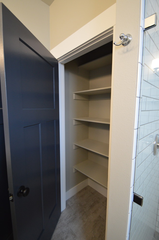 Cette photo montre un petit placard dressing chic neutre avec un placard sans porte, des portes de placard beiges, sol en stratifié et un sol beige.