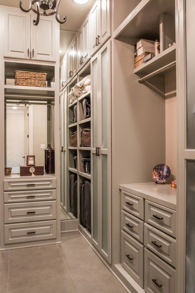 Exempel på ett mycket stort klassiskt walk-in-closet för könsneutrala, med luckor med upphöjd panel, bruna skåp, klinkergolv i porslin och brunt golv
