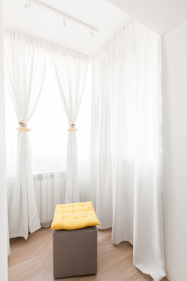 Cette image montre un petit dressing room design neutre avec un placard sans porte, des portes de placard blanches et un sol en contreplaqué.