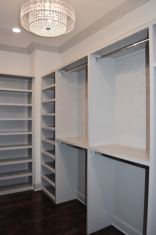 Ejemplo de armario vestidor unisex clásico renovado de tamaño medio con armarios abiertos, puertas de armario beige y suelo de madera oscura