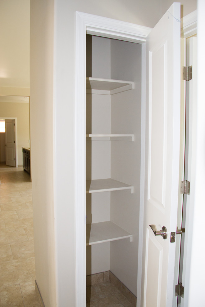 Cette photo montre un petit placard dressing chic neutre avec un placard sans porte, des portes de placard blanches, un sol en carrelage de céramique et un sol beige.