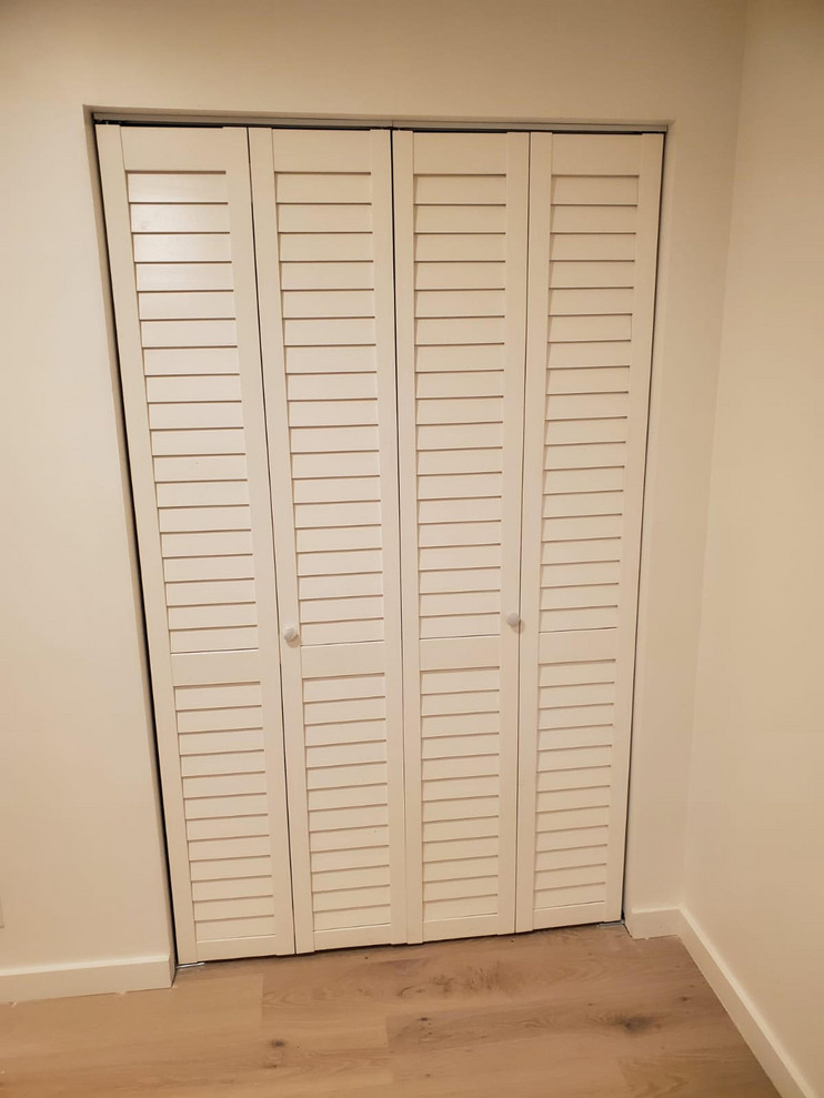 Ejemplo de armario moderno pequeño con suelo de madera clara y suelo multicolor