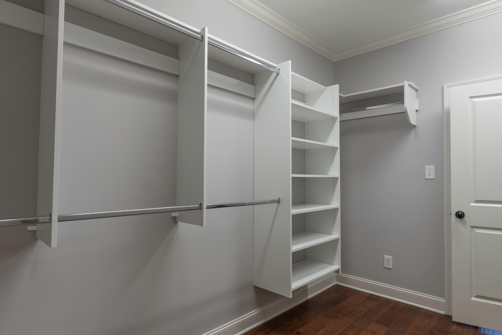 Ejemplo de armario vestidor unisex tradicional renovado de tamaño medio con armarios abiertos, puertas de armario blancas y suelo de madera en tonos medios