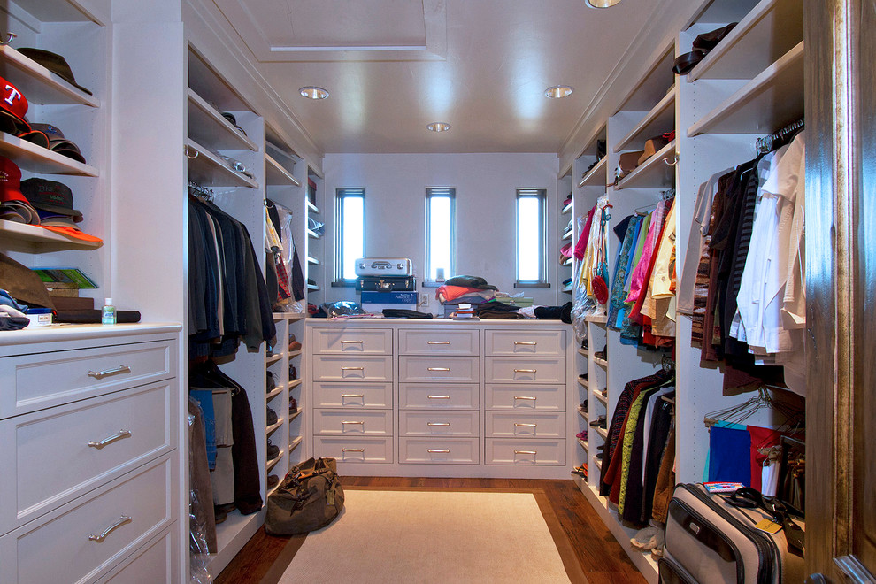 Imagen de vestidor unisex de estilo americano grande con armarios con paneles empotrados, puertas de armario blancas y suelo de madera clara