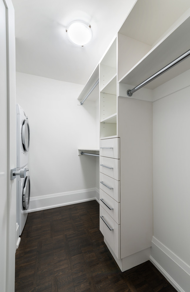 Imagen de armario vestidor unisex contemporáneo pequeño con armarios con paneles lisos, suelo de madera oscura y puertas de armario blancas