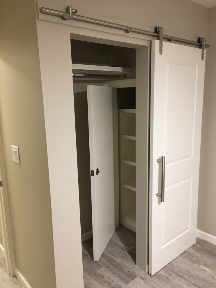 Imagen de armario unisex contemporáneo pequeño con armarios con paneles con relieve, puertas de armario blancas, suelo de baldosas de porcelana y suelo gris