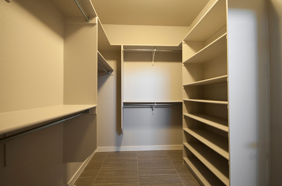 Example of a mid-sized trendy gender-neutral ceramic tile walk-in closet design in Austin