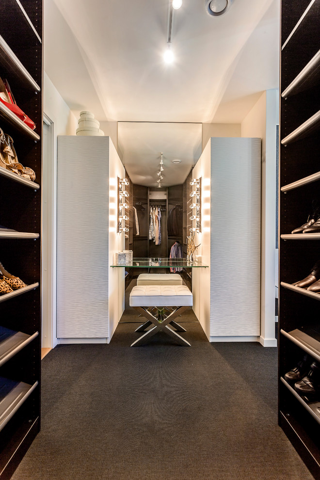 Inspiration for a contemporary gender neutral wardrobe in Other with dark wood cabinets, carpet and black floors.