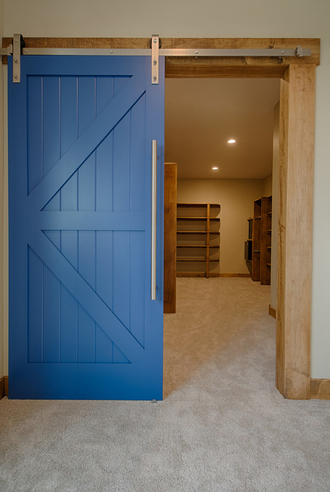 Ejemplo de armario vestidor unisex contemporáneo grande con armarios abiertos, puertas de armario de madera oscura, moqueta y suelo beige