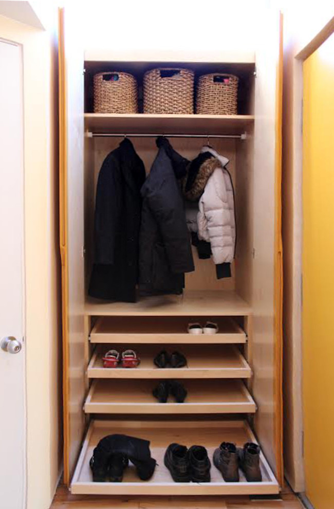 Design ideas for a small contemporary gender neutral standard wardrobe in New York with flat-panel cabinets, light wood cabinets and light hardwood flooring.