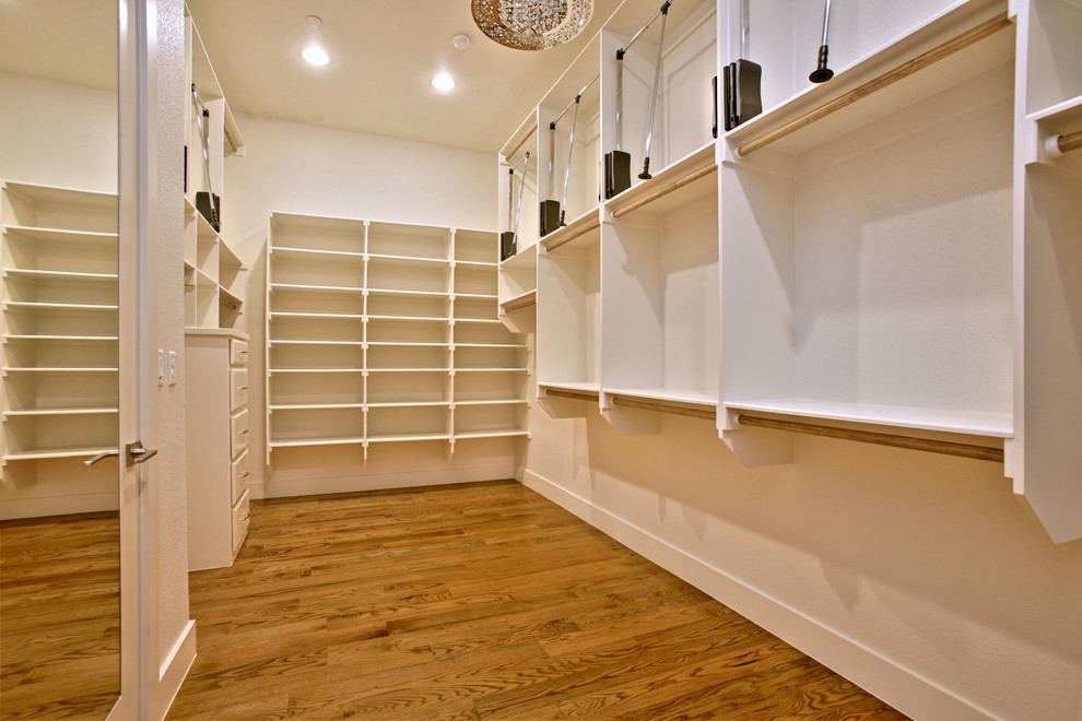 Walk-in closet - huge contemporary gender-neutral medium tone wood floor walk-in closet idea in Dallas with open cabinets and white cabinets