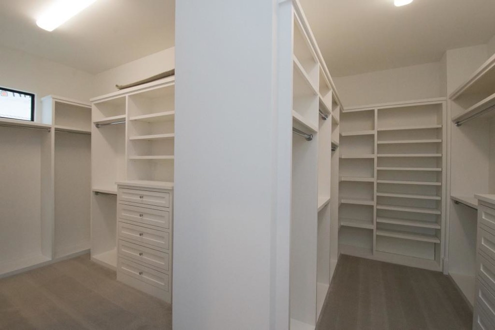 Modelo de armario vestidor actual grande con armarios con paneles empotrados, puertas de armario blancas, moqueta y suelo gris