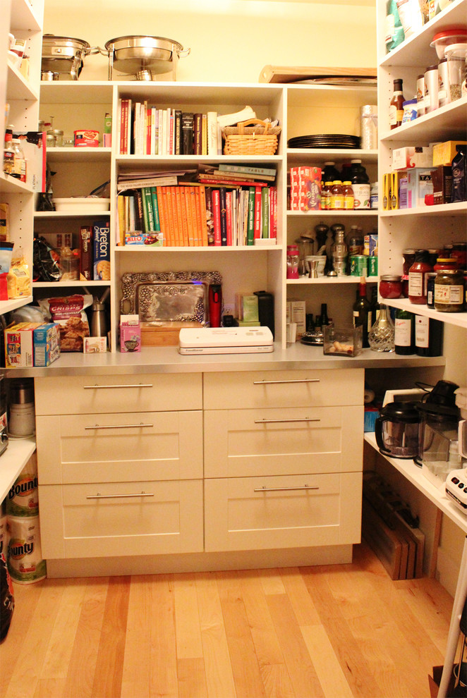 Imagen de armario y vestidor actual con armarios con paneles lisos, puertas de armario blancas y suelo de madera clara