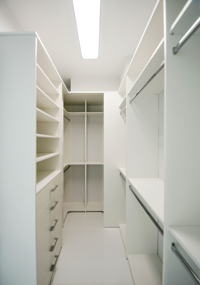 На фото: гардеробная комната среднего размера в стиле модернизм с открытыми фасадами, белыми фасадами, полом из керамогранита и белым полом с