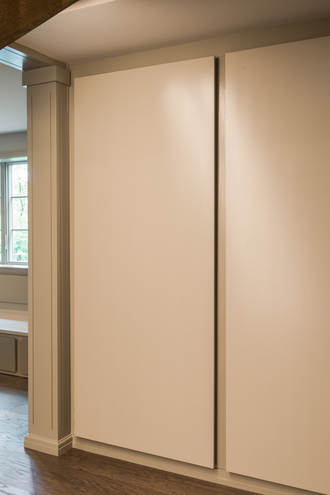Immagine di un piccolo armadio o armadio a muro unisex design con ante lisce, ante grigie e pavimento in legno massello medio