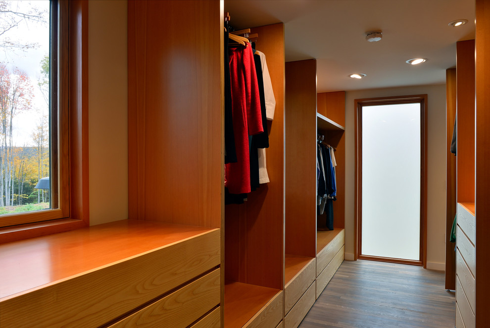 Foto di uno spazio per vestirsi unisex design con ante lisce, pavimento in legno massello medio e ante in legno chiaro