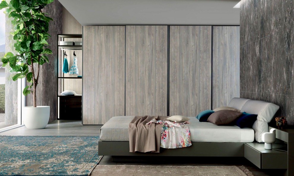 マイアミにある広いコンテンポラリースタイルのおしゃれな壁面クローゼット (フラットパネル扉のキャビネット、淡色木目調キャビネット、コンクリートの床、グレーの床) の写真