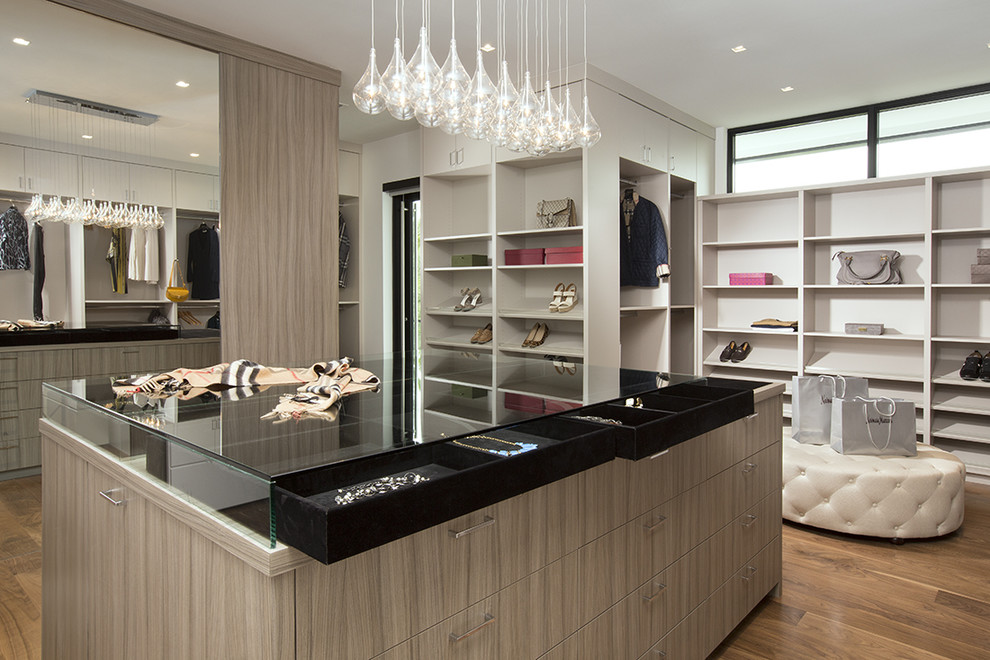 This is an example of a contemporary dressing room for women in Miami with open cabinets and medium hardwood flooring.
