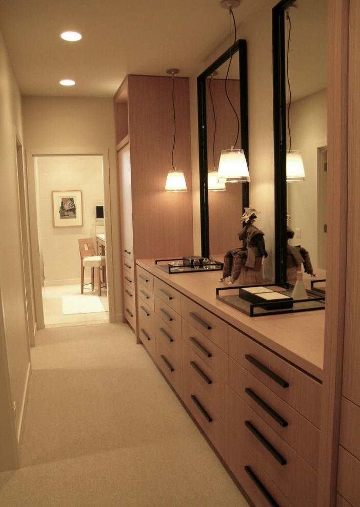 Foto di uno spazio per vestirsi unisex classico con ante lisce, ante in legno chiaro, moquette e pavimento beige