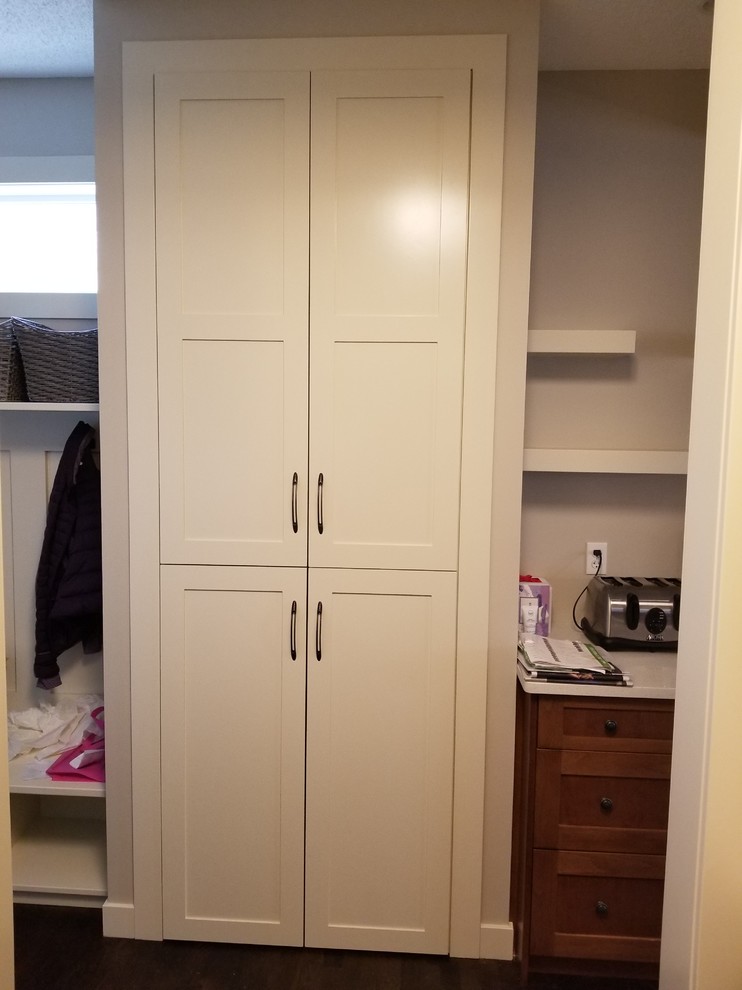 Photo of a medium sized walk-in wardrobe in Calgary with shaker cabinets, beige cabinets, medium hardwood flooring and brown floors.