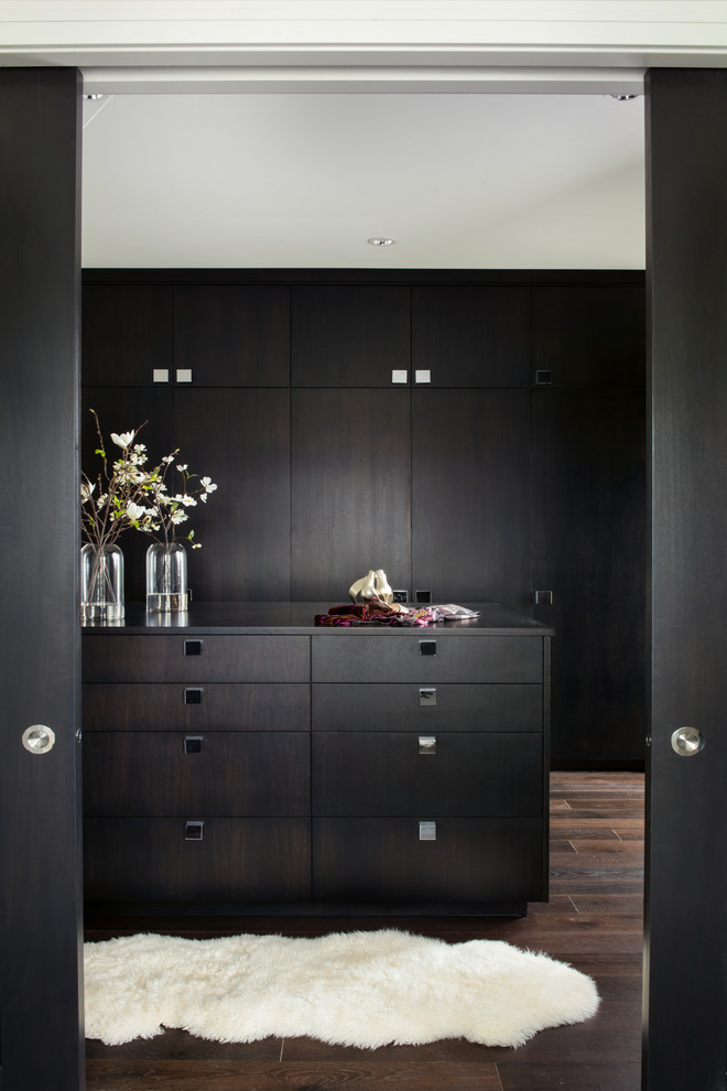 Imagen de armario vestidor unisex contemporáneo grande con armarios con paneles lisos, puertas de armario de madera en tonos medios y suelo de madera oscura