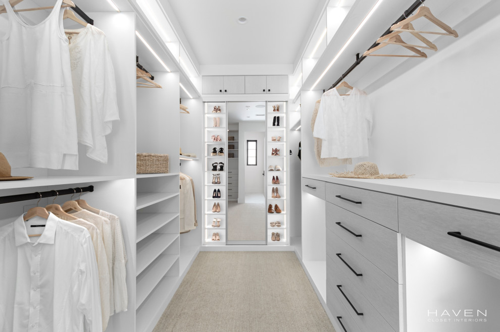Design ideas for a medium sized coastal gender neutral walk-in wardrobe in Orange County with flat-panel cabinets, white cabinets, carpet and beige floors.