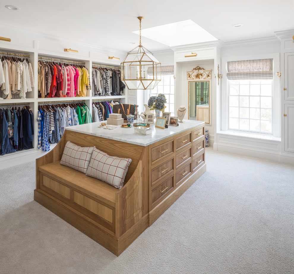 This is an example of a traditional dressing room for women in Salt Lake City with recessed-panel cabinets, medium wood cabinets, carpet and grey floors.