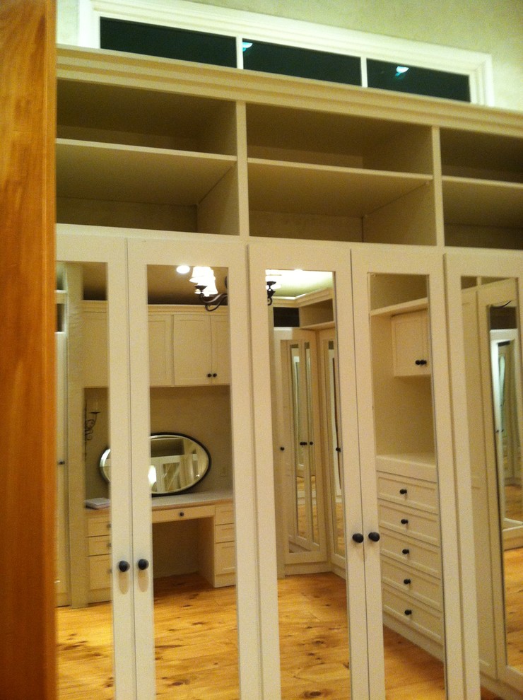 Foto de armario vestidor unisex mediterráneo grande con armarios estilo shaker, puertas de armario blancas y suelo de madera en tonos medios