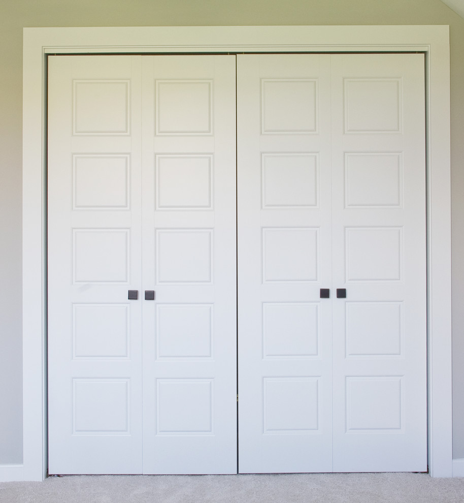 На фото: шкаф в нише унисекс в стиле кантри с белыми фасадами, ковровым покрытием и серым полом с