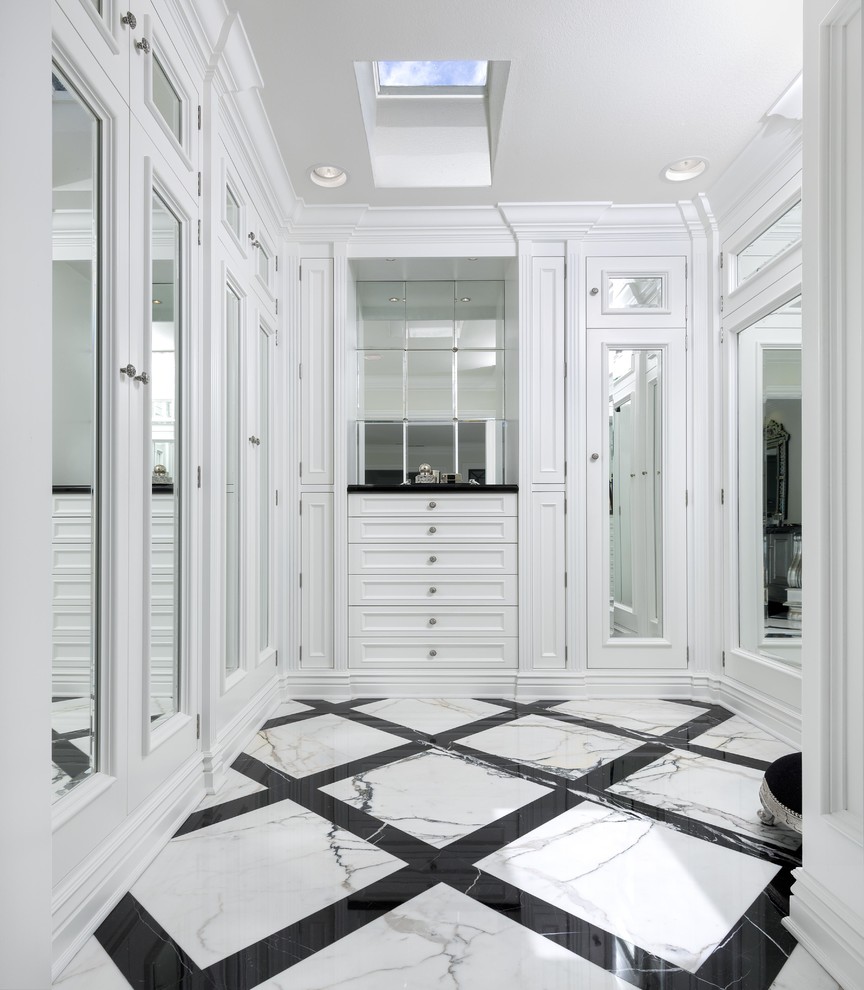 Inspiration pour un dressing room traditionnel neutre avec un placard avec porte à panneau encastré, des portes de placard blanches et un sol multicolore.