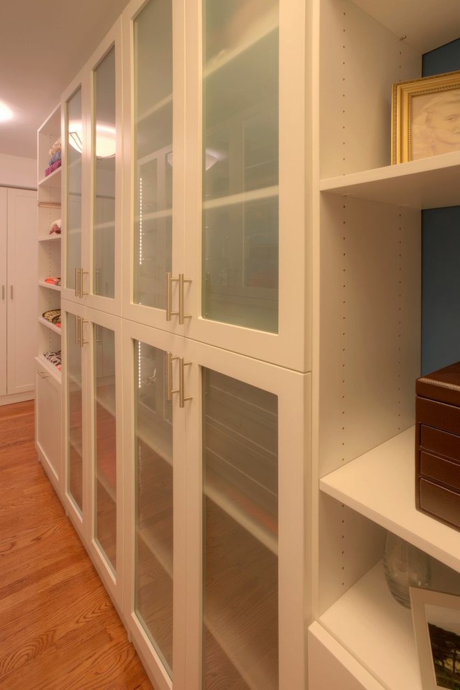 Foto de armario vestidor unisex contemporáneo grande con armarios tipo vitrina y suelo de madera oscura