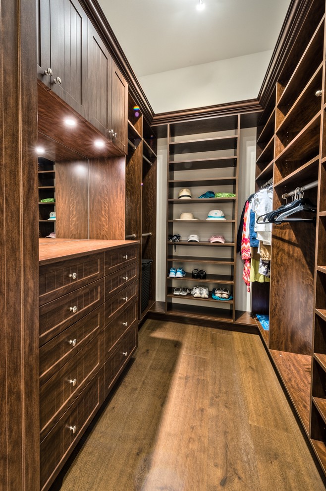 Inspiration for a medium sized beach style gender neutral walk-in wardrobe in Miami with recessed-panel cabinets, dark wood cabinets and medium hardwood flooring.