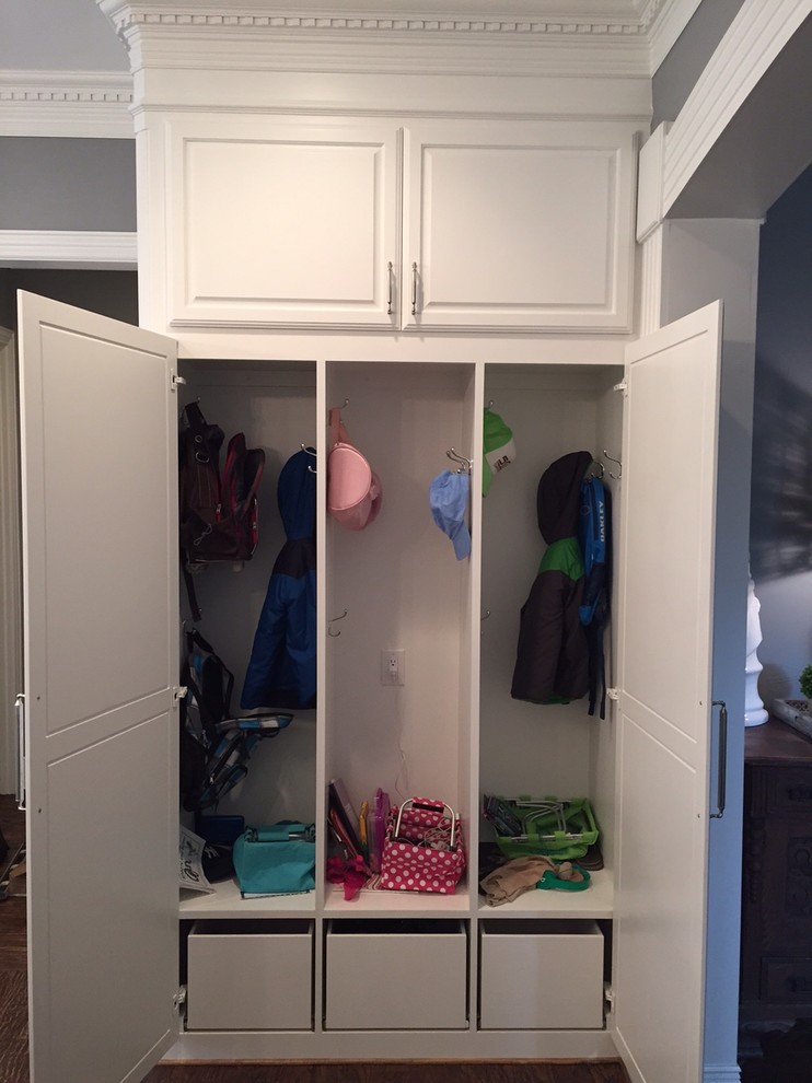 Example of a small classic gender-neutral dark wood floor reach-in closet design in Dallas with raised-panel cabinets and white cabinets