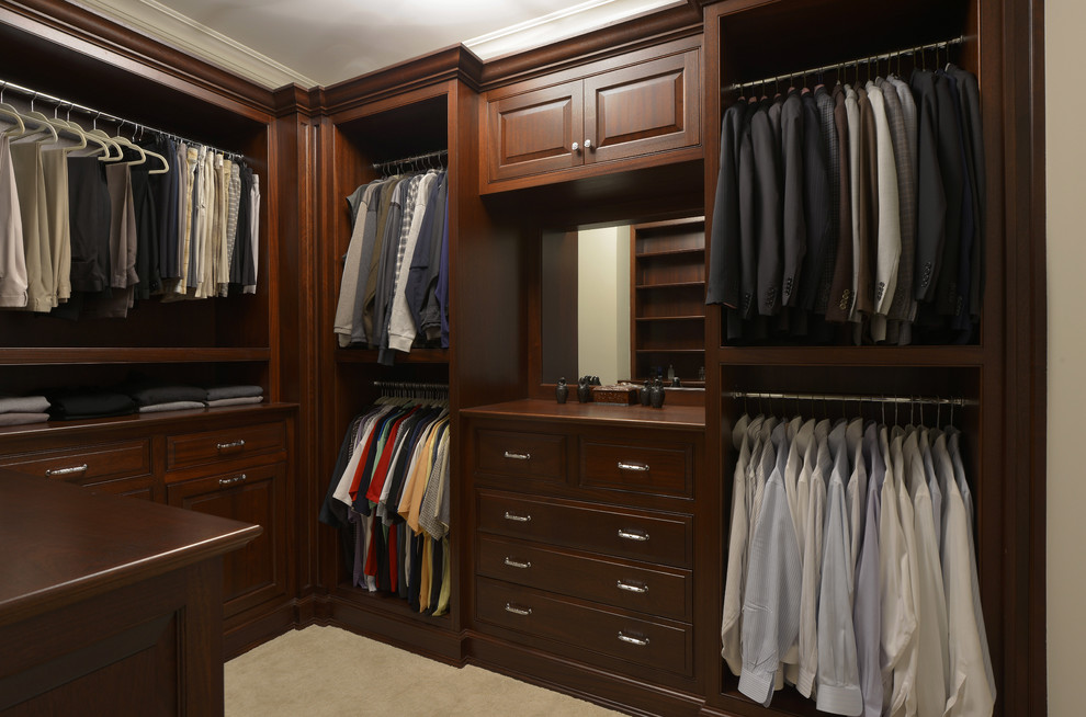 Ejemplo de armario vestidor de hombre clásico de tamaño medio con armarios con paneles con relieve, puertas de armario de madera en tonos medios, moqueta y suelo beige