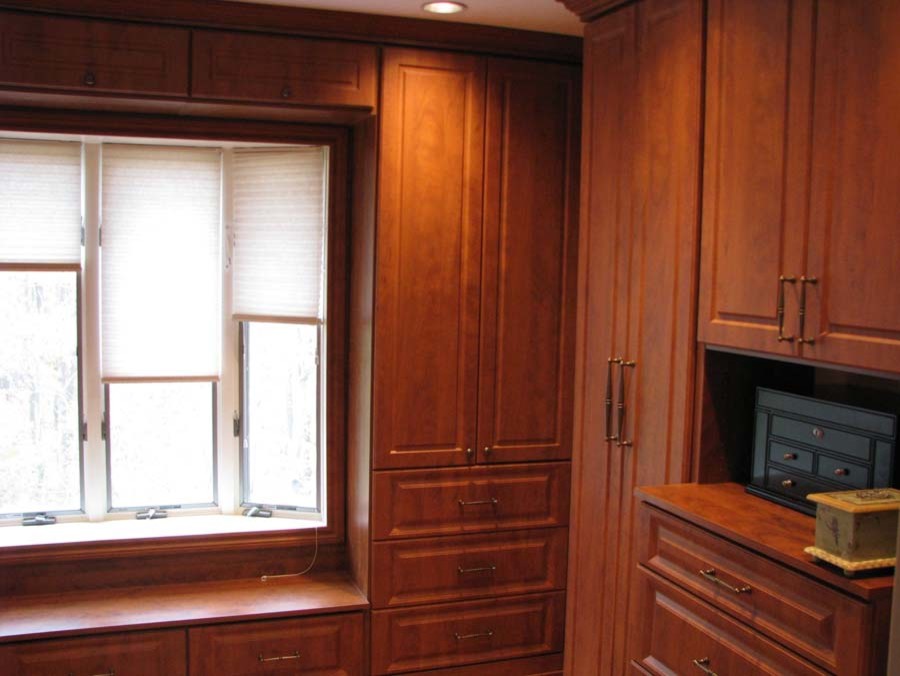Large traditional gender neutral walk-in wardrobe in New York with medium wood cabinets.