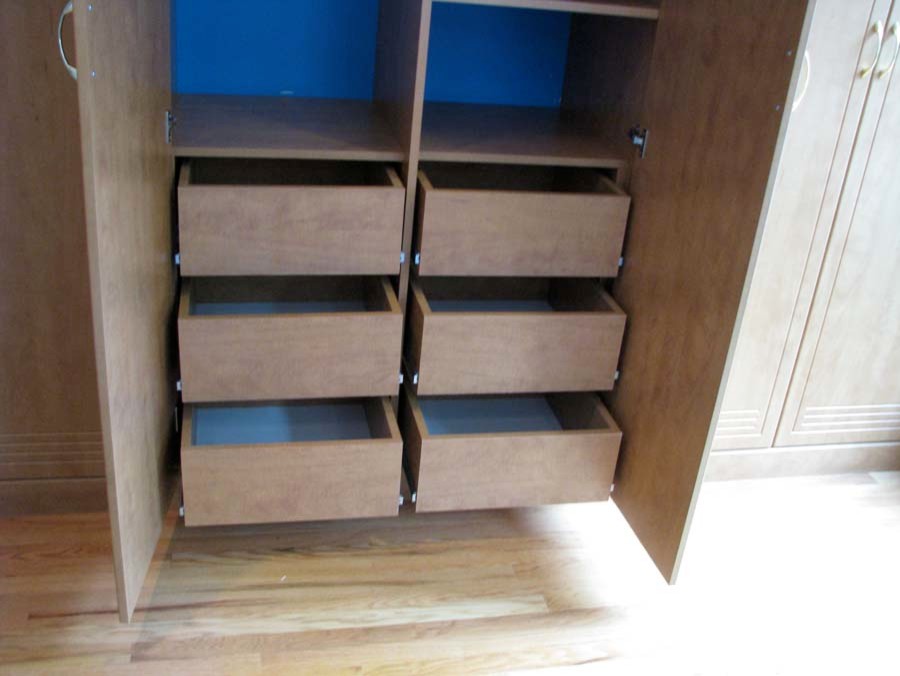 Foto de armario unisex clásico grande con puertas de armario de madera clara y suelo de madera clara