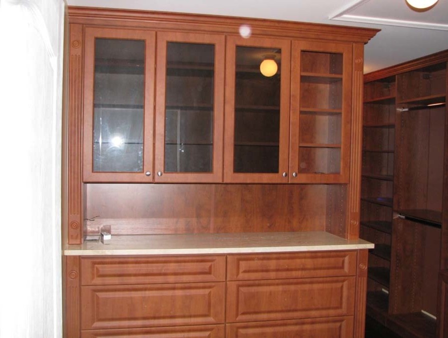 Ejemplo de armario vestidor unisex clásico grande con puertas de armario de madera oscura