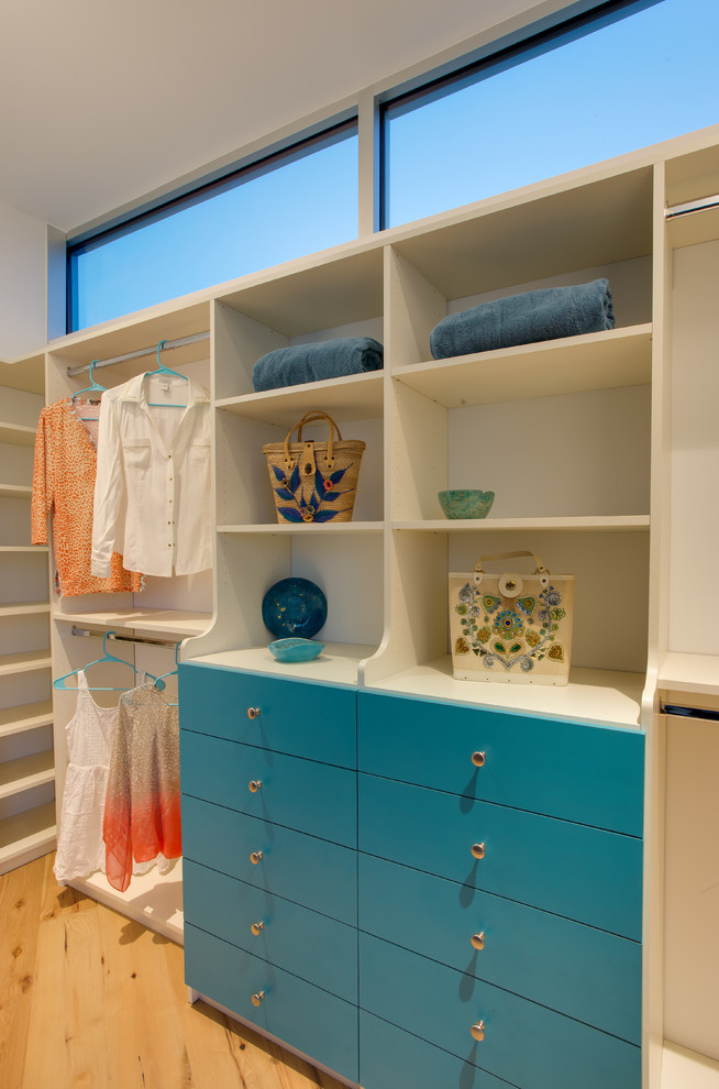 Foto de armario vestidor de mujer tradicional renovado de tamaño medio con armarios con paneles lisos, puertas de armario azules, suelo de madera clara y suelo marrón