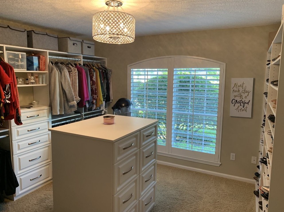 Imagen de armario vestidor clásico de tamaño medio con armarios con paneles lisos, puertas de armario blancas, moqueta y suelo marrón