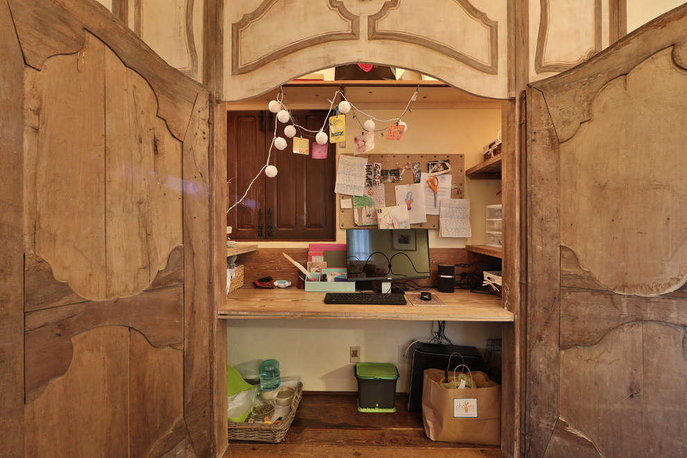 Immagine di un piccolo armadio o armadio a muro per donna rustico con ante con bugna sagomata, ante con finitura invecchiata, pavimento in legno massello medio e pavimento marrone