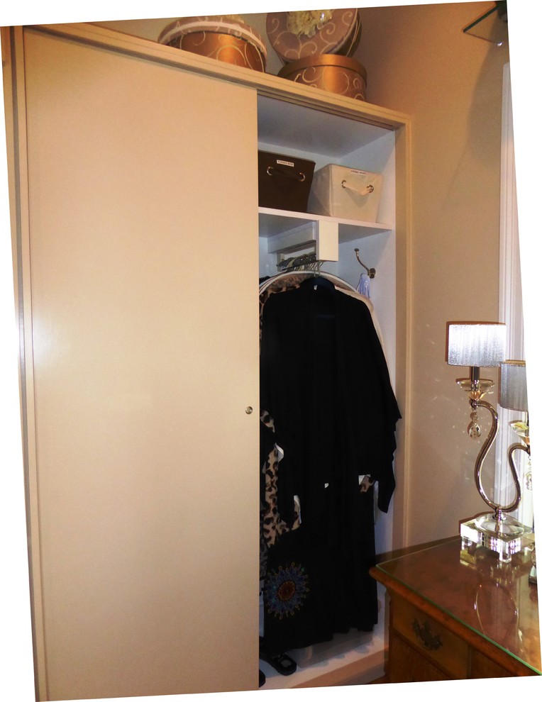 Aménagement d'un placard dressing bord de mer de taille moyenne pour une femme avec un placard à porte shaker, des portes de placard beiges et un sol en bois brun.
