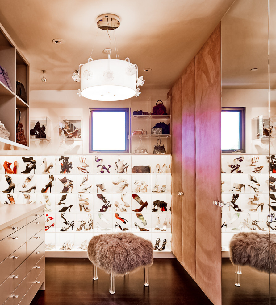 Modern inredning av ett mycket stort walk-in-closet för kvinnor, med öppna hyllor, vita skåp, mörkt trägolv och brunt golv