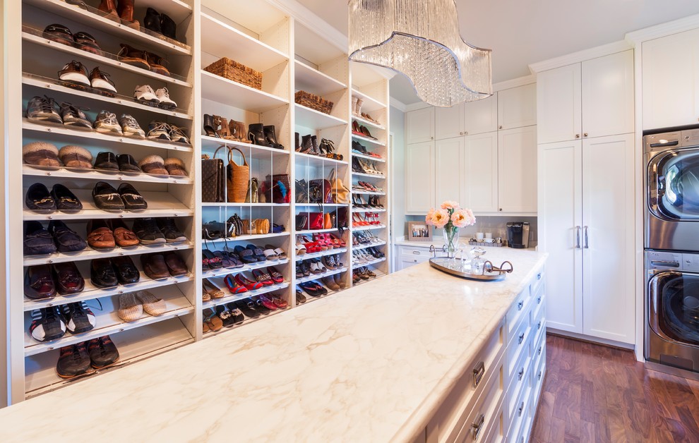 This is an example of a large classic gender neutral dressing room in Houston with shaker cabinets, white cabinets and medium hardwood flooring.
