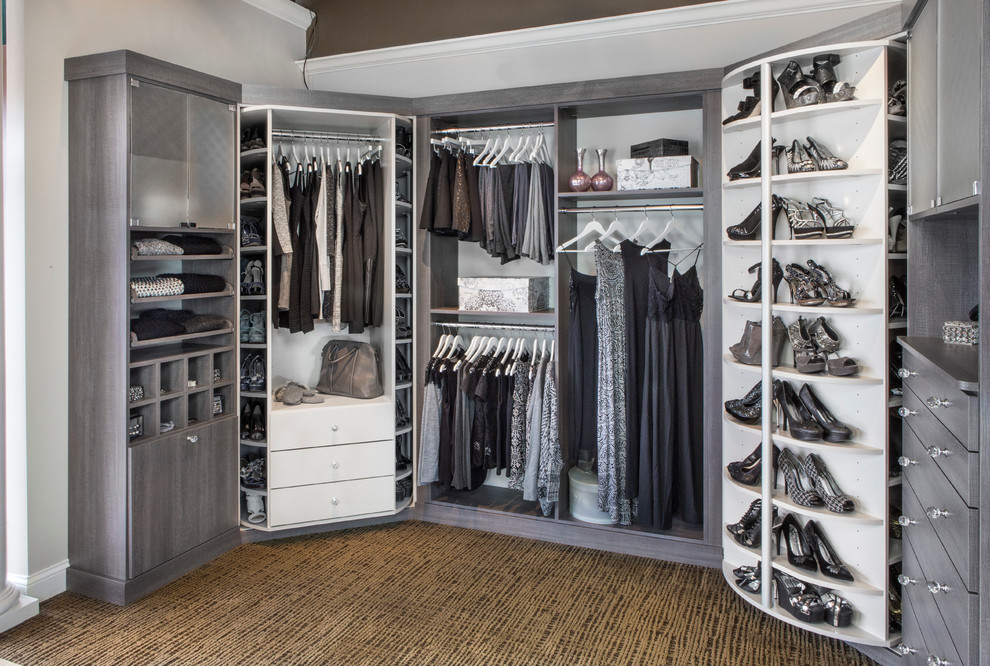 Imagen de armario vestidor de mujer tradicional grande con armarios abiertos, puertas de armario grises, moqueta y suelo marrón